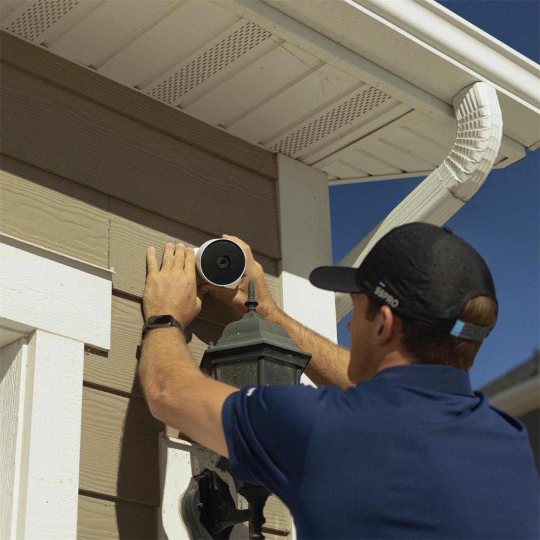 An Elite Home Pro installing an outdoor camera at the front door